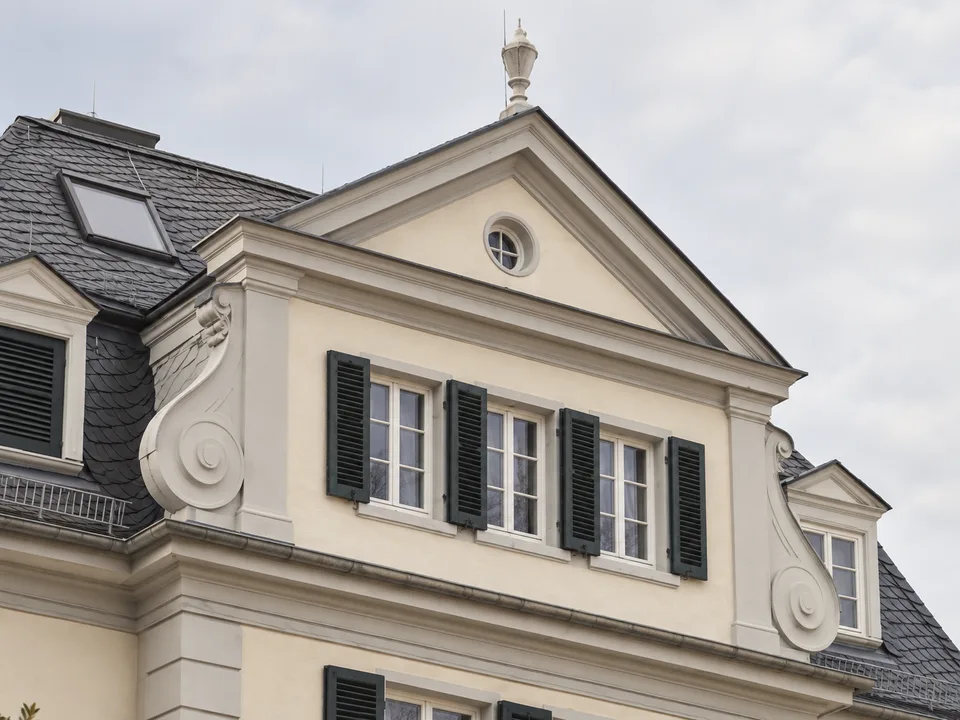 Illustrative Architekturansicht eines historischen Giebels mit Voluten, Fensterläden und Schieferdach